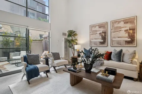 a living room with furniture plant and a large window