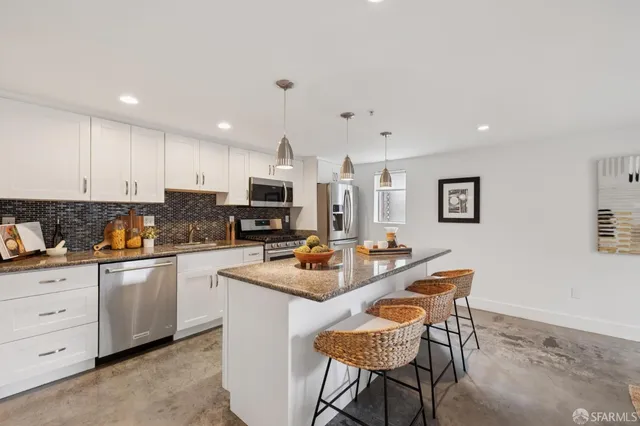 a kitchen with stainless steel appliances kitchen island granite countertop a sink and cabinets