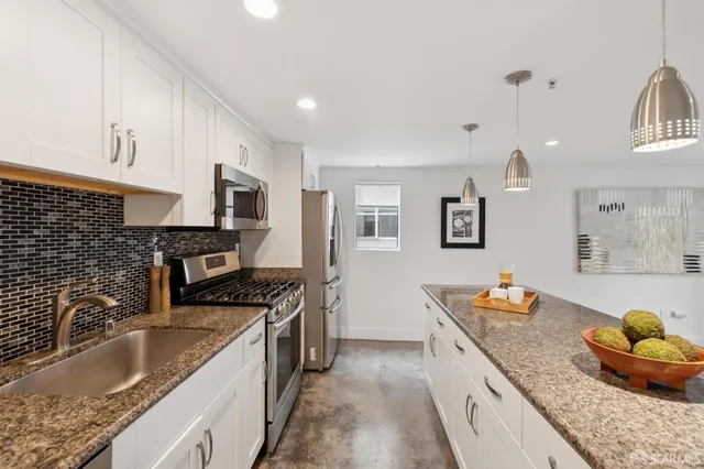 a kitchen with stainless steel appliances granite countertop a sink stove and refrigerator