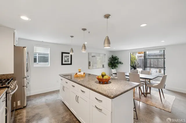 a kitchen with stainless steel appliances white cabinets and a stove top oven