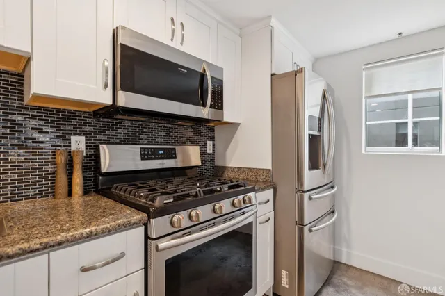 a kitchen with a sink a microwave and cabinets