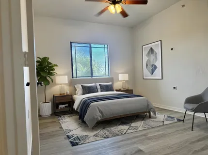 a bedroom with a bed lamp and a potted plant