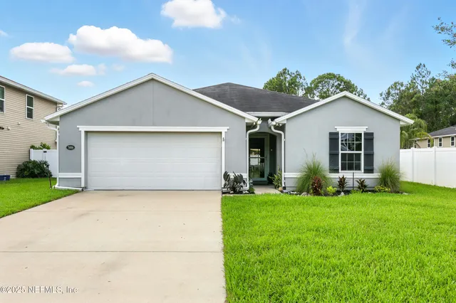 a view of a house with a yard and potted plants