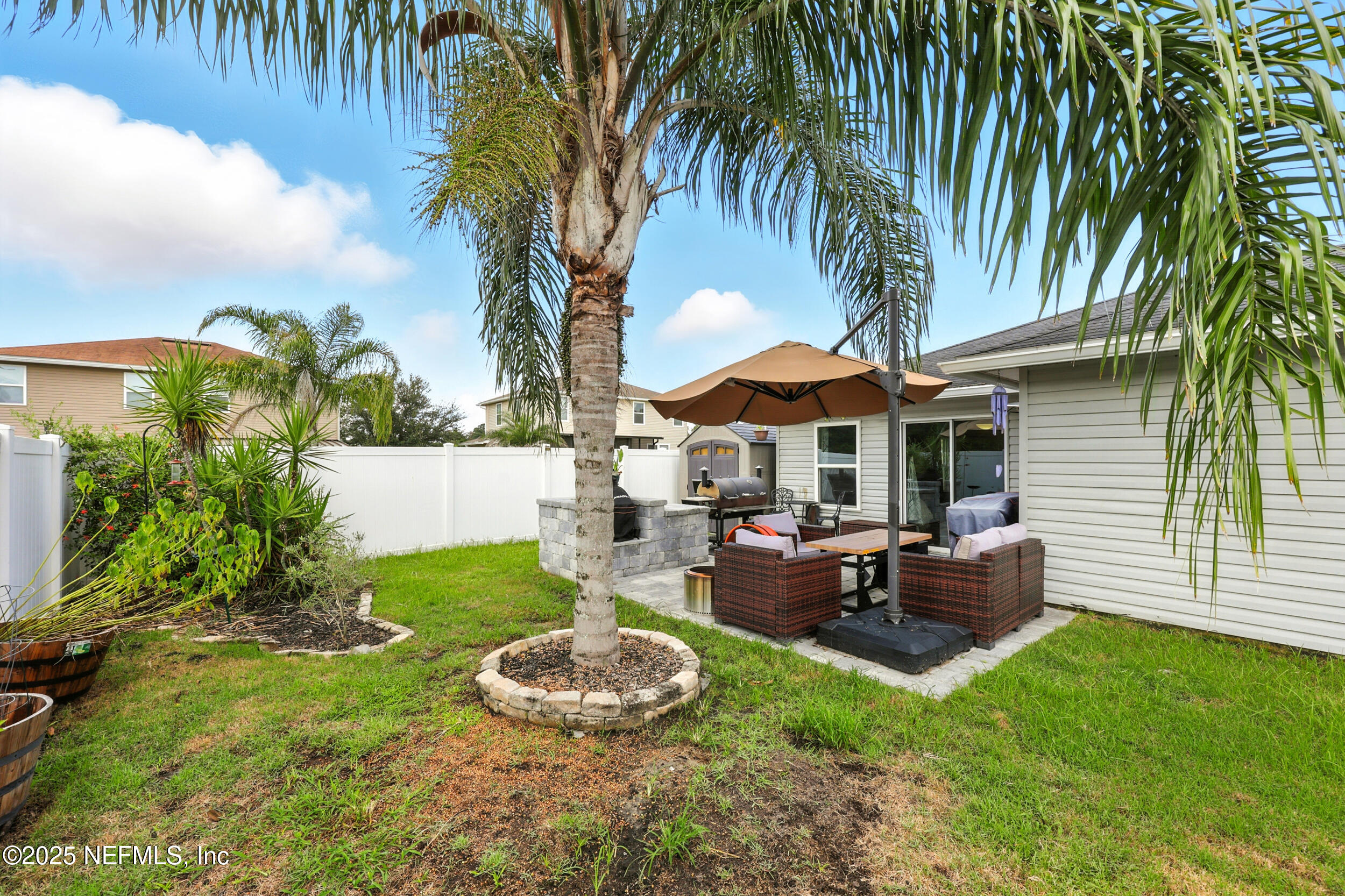 76866 Timbercreek Boulevard Yulee, FL 32097 - Photo 29 of 33 a view of a backyard with table and chairs potted plants and palm tree