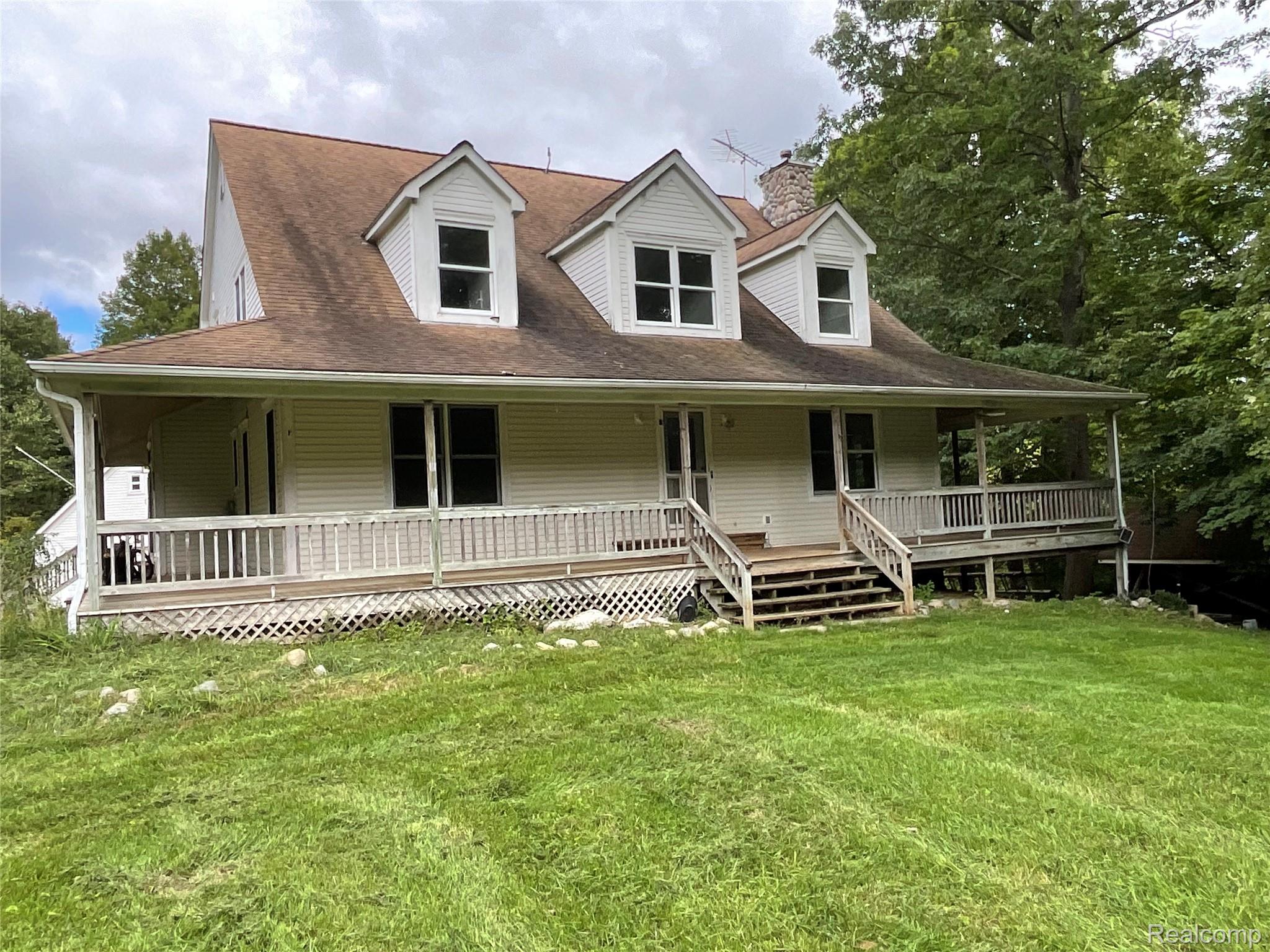 3425 East Sutton Road Dryden, MI 48428 - Photo 70 of 74 Farmhouse-style home with covered porch, a chimney, a front lawn, and a shingled roof