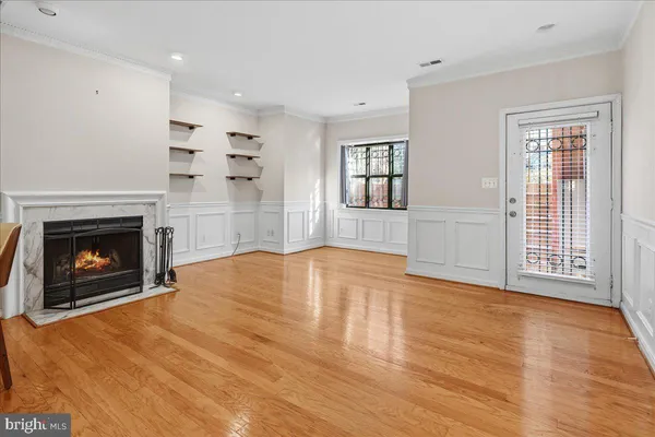 a view of empty room with wooden floor and fireplace
