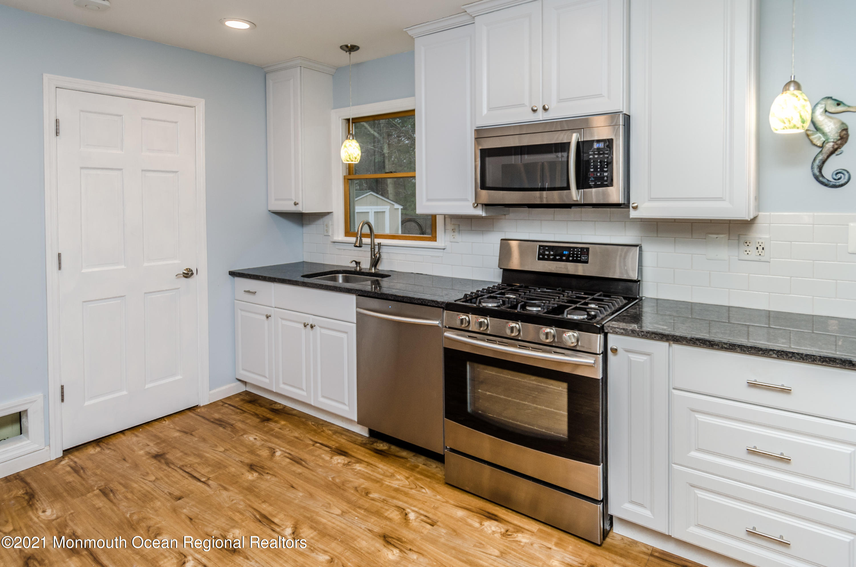 58 Pinewood Drive Brick, NJ 08724 - Photo 13 of 30 a kitchen with granite countertop a stove top oven microwave and cabinets