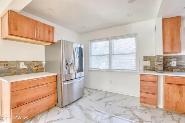a kitchen with granite countertop a refrigerator and a stove top oven