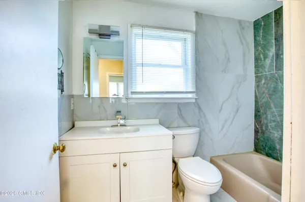 a bathroom with a sink toilet vanity and tub