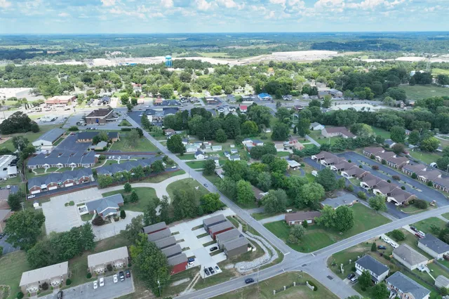 an aerial view of residential houses with outdoor space and trees