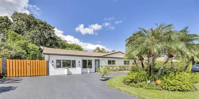 a front view of a house with a yard and potted plants