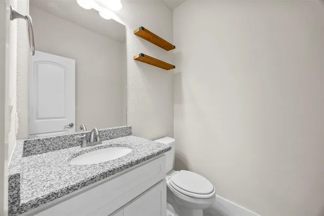 a kitchen with stainless steel appliances granite countertop a stove top oven a sink dishwasher a dining table and chairs with wooden floor