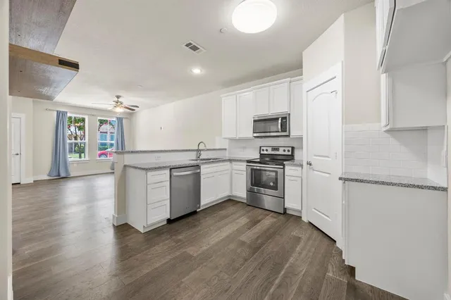 a kitchen with granite countertop a sink stove and refrigerator