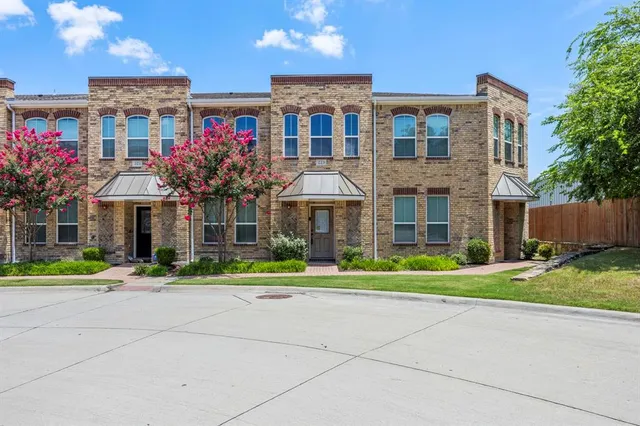 a front view of a house with a yard and potted plants