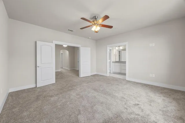 an empty room with closet and a chandelier fan