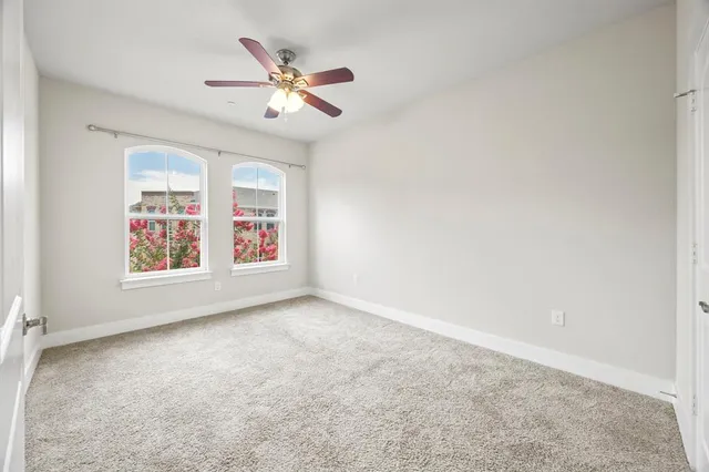 an empty room with closet and a ceiling fan