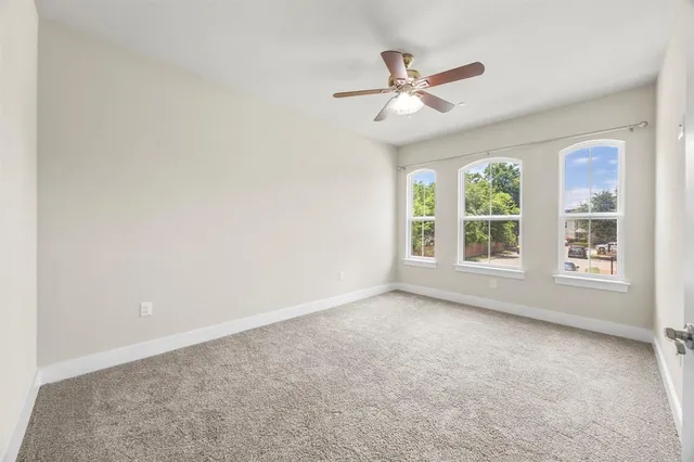 an empty room with closet and a ceiling fan