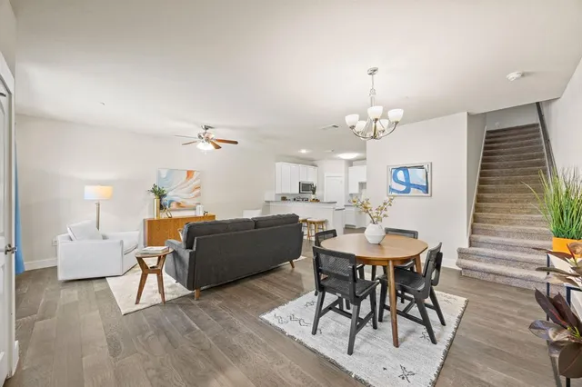 a view of a kitchen with a dishwasher a kitchen island hardwood floor and a ceiling fan
