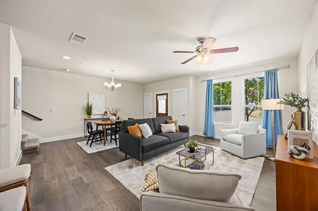 a living room with furniture and a wooden floor