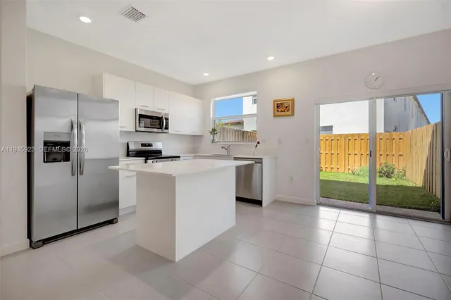 a kitchen with a refrigerator and a stove top oven