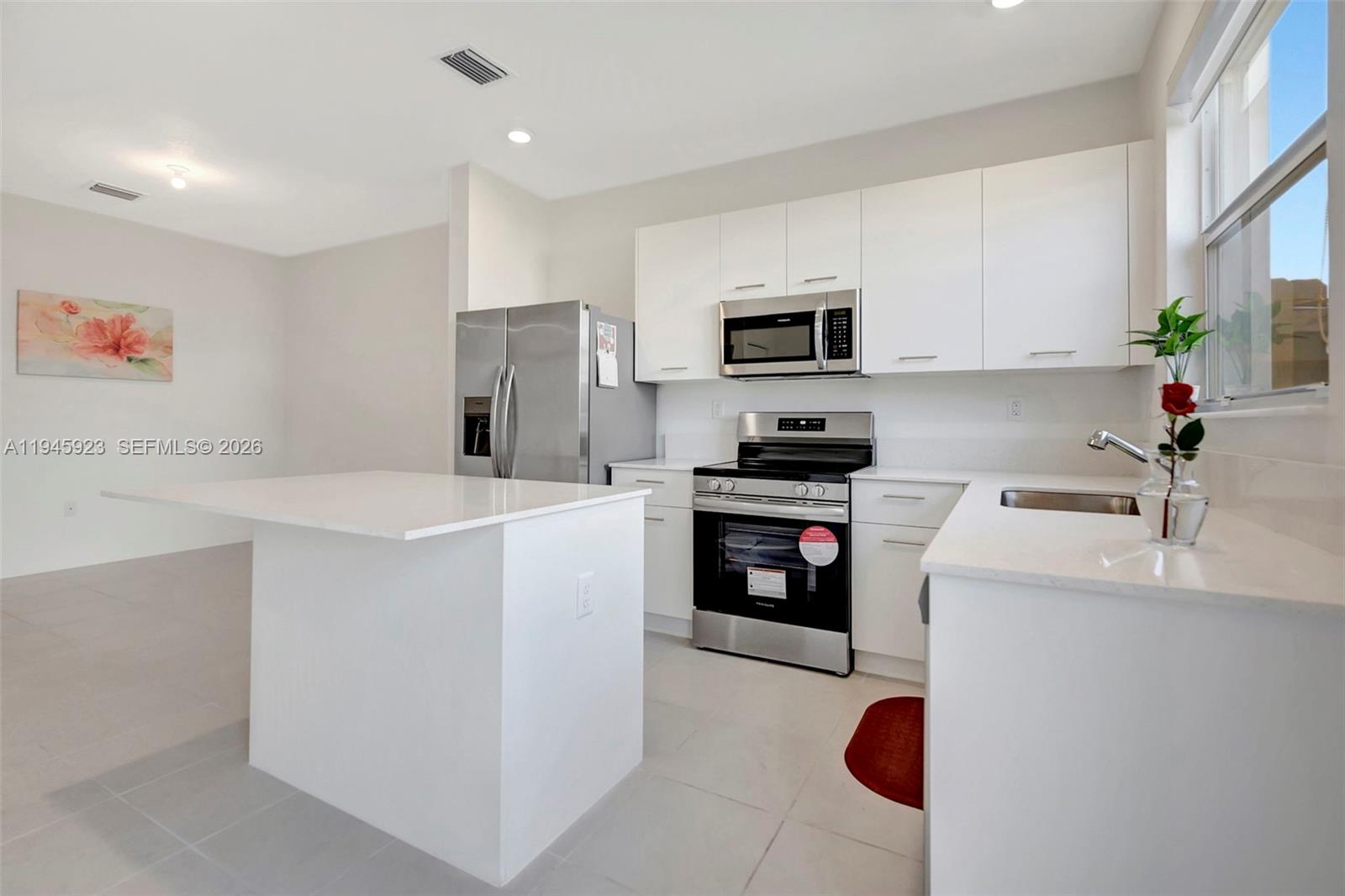 2455 Northwest 119th Street Miami, FL 33167 - Photo 6 of 38 a kitchen with kitchen island a sink stainless steel appliances and cabinets