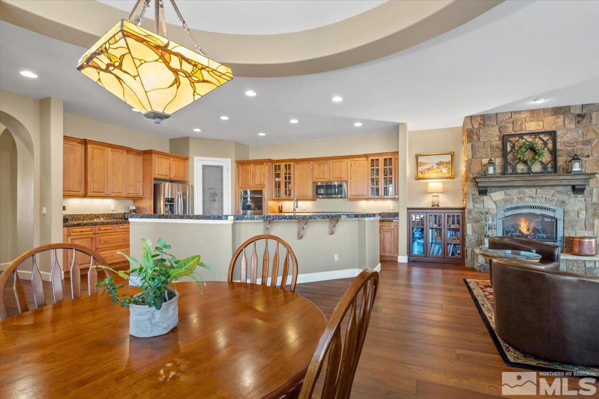 15185 Chateau Avenue Reno, NV 89511 - Photo 14 of 39 a dining room with furniture a fireplace and wooden floor
