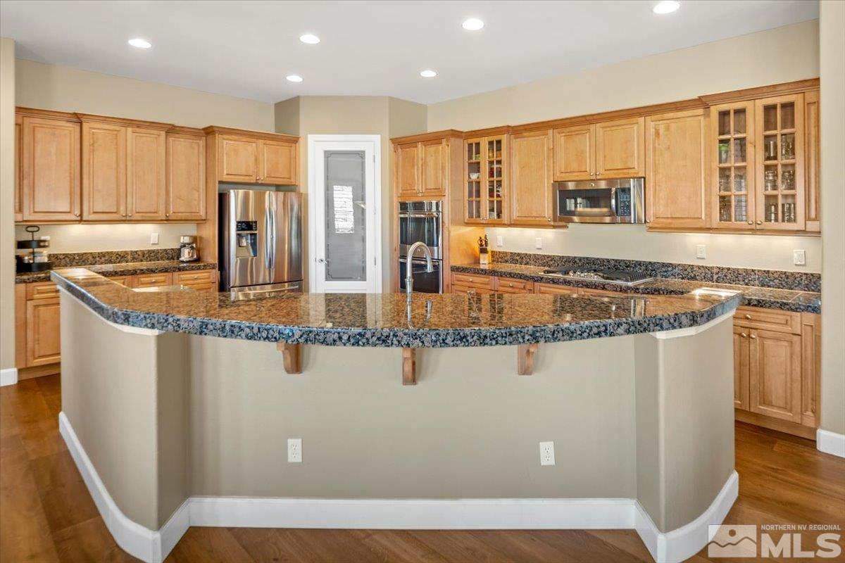 15185 Chateau Avenue Reno, NV 89511 - Photo 10 of 39 a kitchen with stainless steel appliances granite countertop a refrigerator a stove and a sink with wooden cabinets