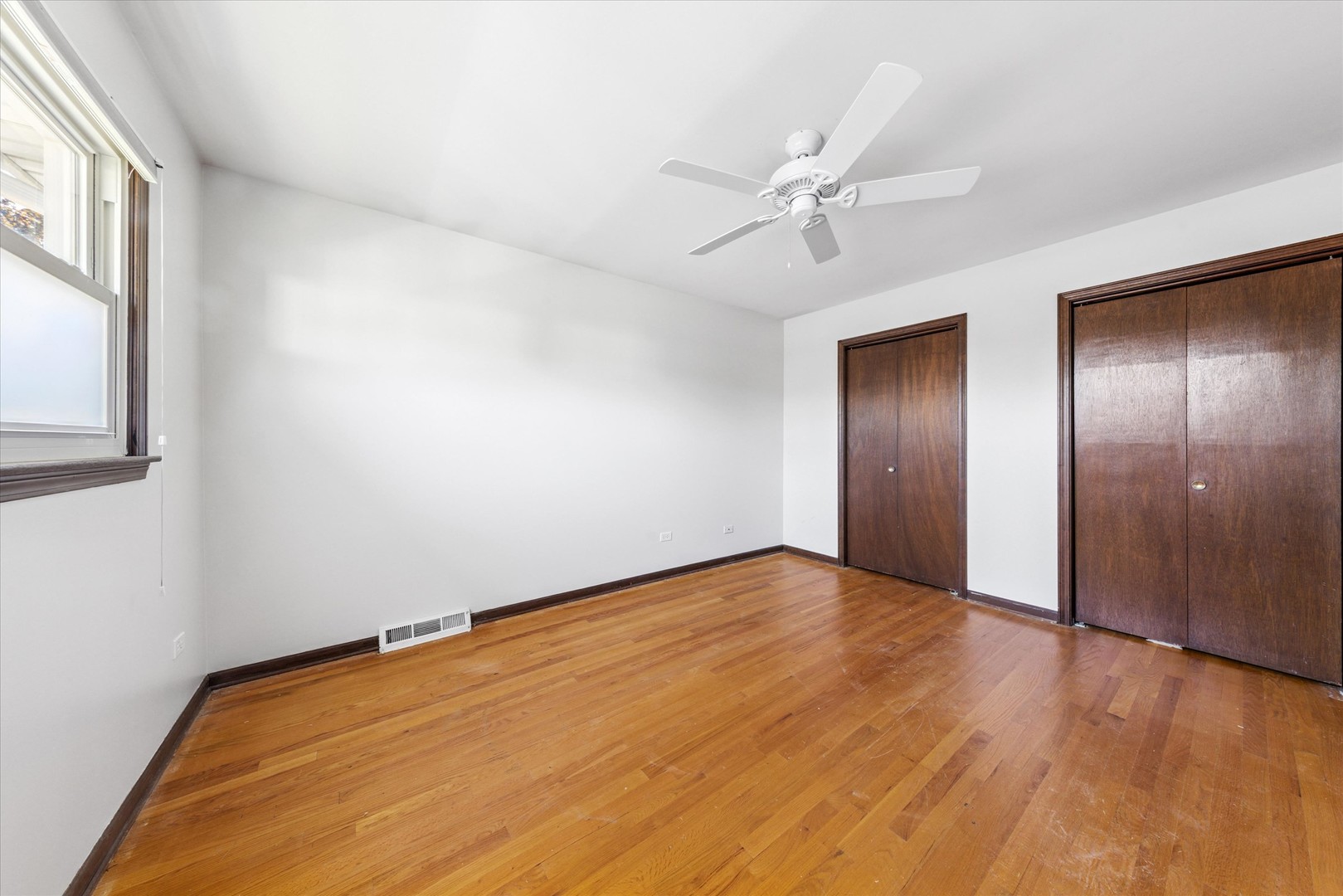 1310 Iroquois Lane Darien, IL 60561 - Photo 11 of 22 a view of an empty room with wooden floor and a window