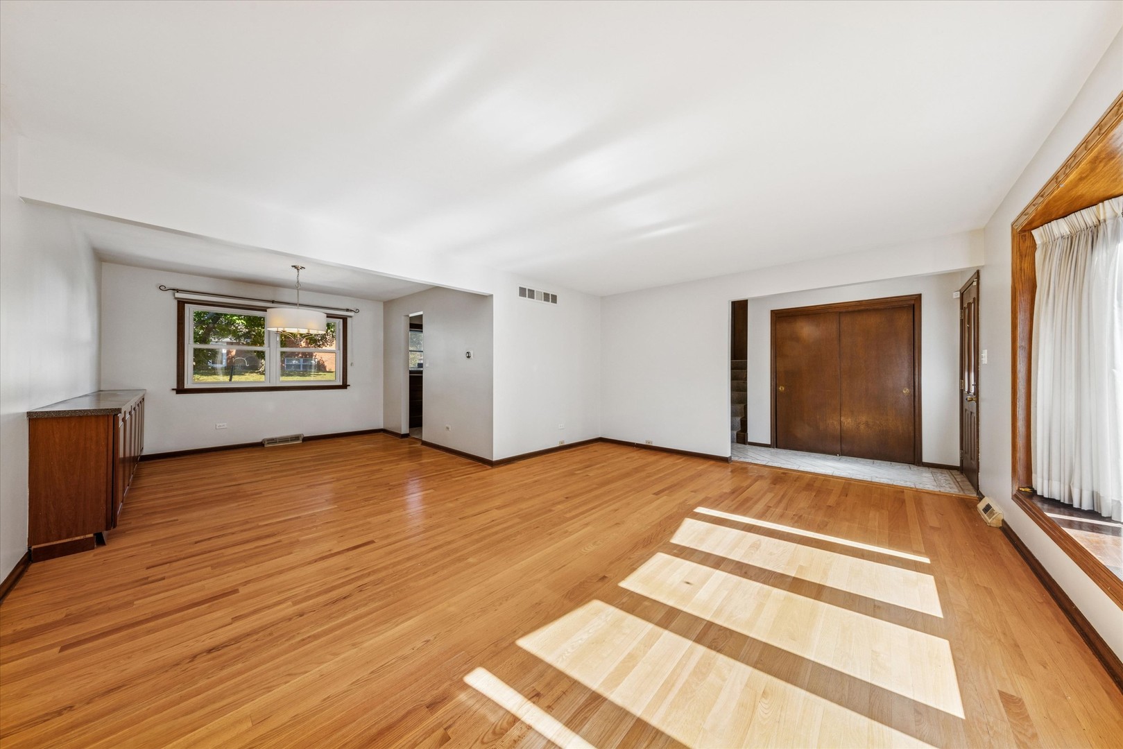 1310 Iroquois Lane Darien, IL 60561 - Photo 3 of 22 a view of an empty room with wooden floor and a window