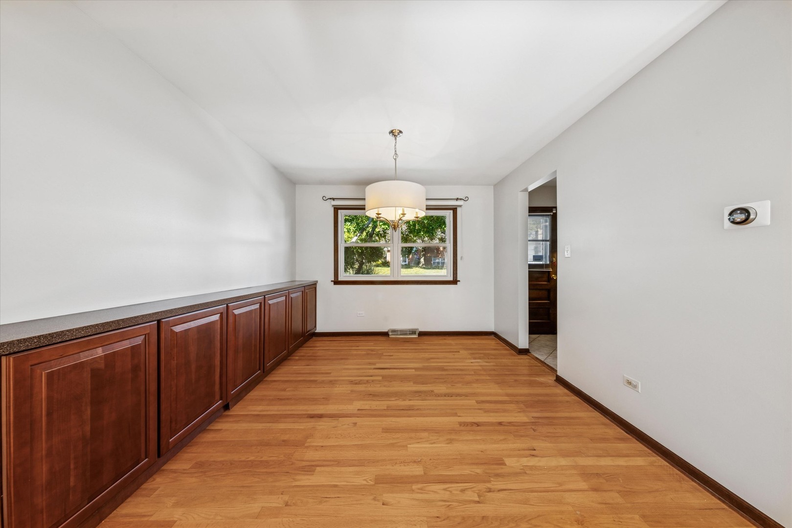 1310 Iroquois Lane Darien, IL 60561 - Photo 5 of 22 wooden floor in an empty room with a window
