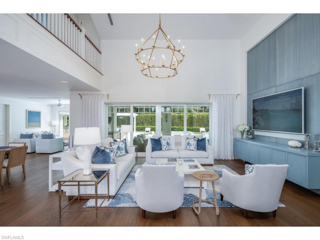 4042 Old Trail Way Naples, FL 34103 - Photo 2 of 20 a living room with furniture a chandelier and a flat screen tv