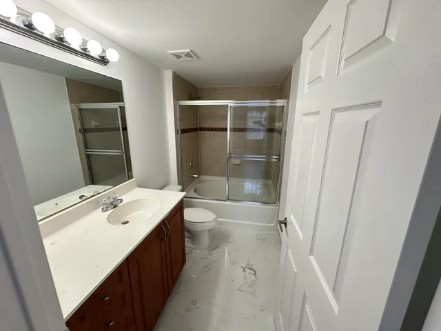 a bathroom with a sink toilet and shower