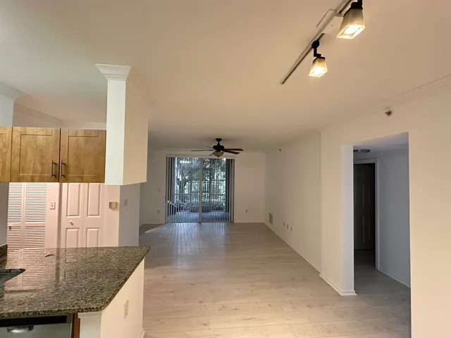 a view of open kitchen with white cabinets and stainless steel appliances