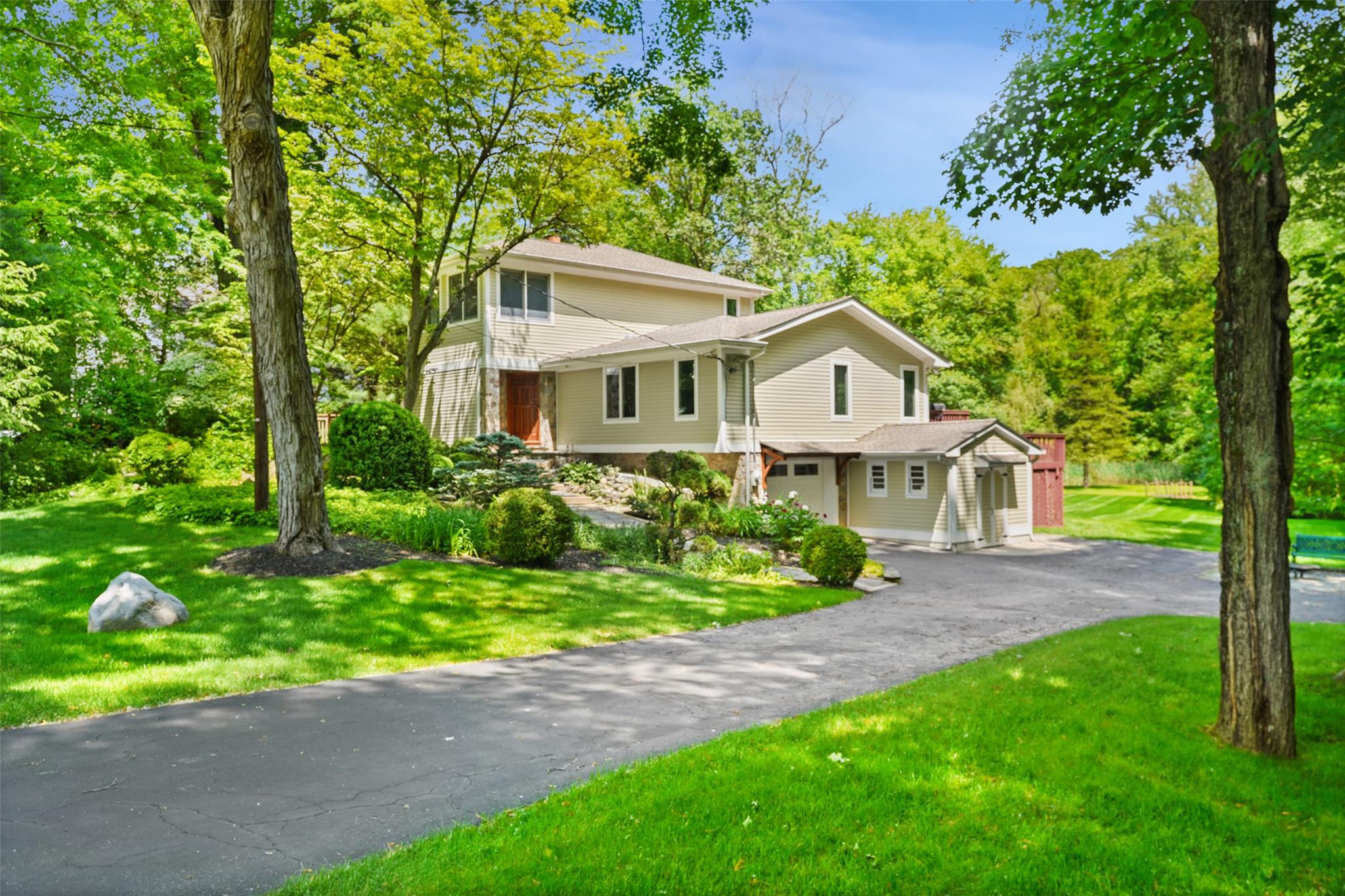 View of front of house with an attached garage, driveway, and a front yard