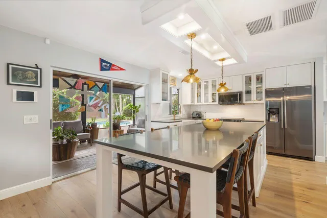 a kitchen with stainless steel appliances granite countertop a table chairs and a refrigerator