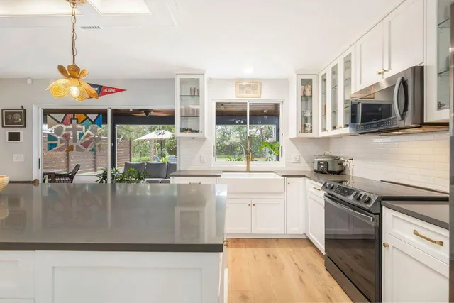 a kitchen with stainless steel appliances granite countertop a stove a sink and a microwave