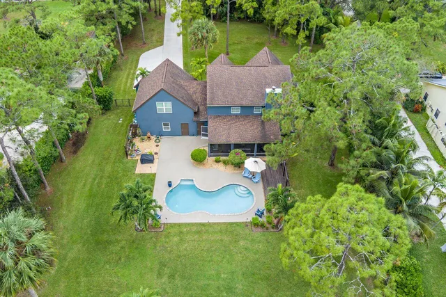 an aerial view of a house with swimming pool and garden