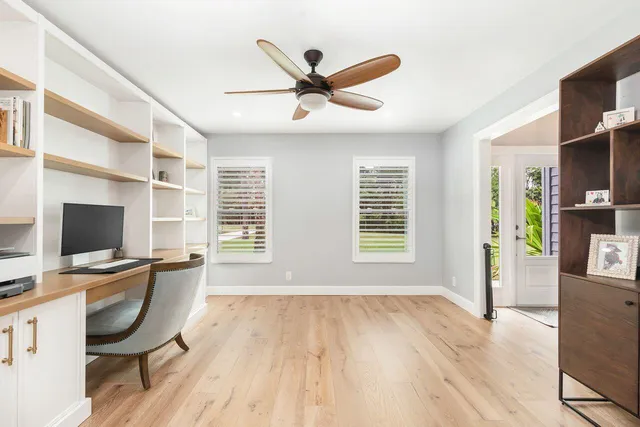 a workspace with wooden floor and windows