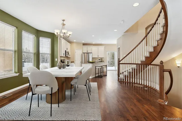 a kitchen with stainless steel appliances granite countertop a stove top oven a refrigerator a sink and dishwasher with wooden floor