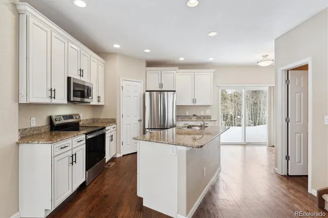 a kitchen with a refrigerator sink and stove