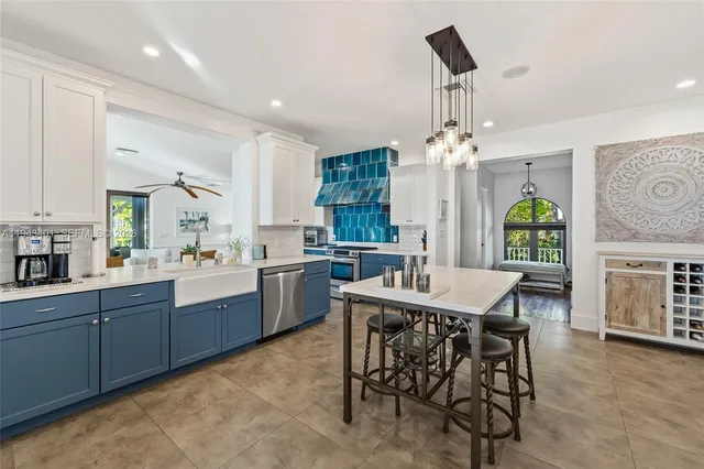 a kitchen with stainless steel appliances granite countertop a sink a stove and white cabinets