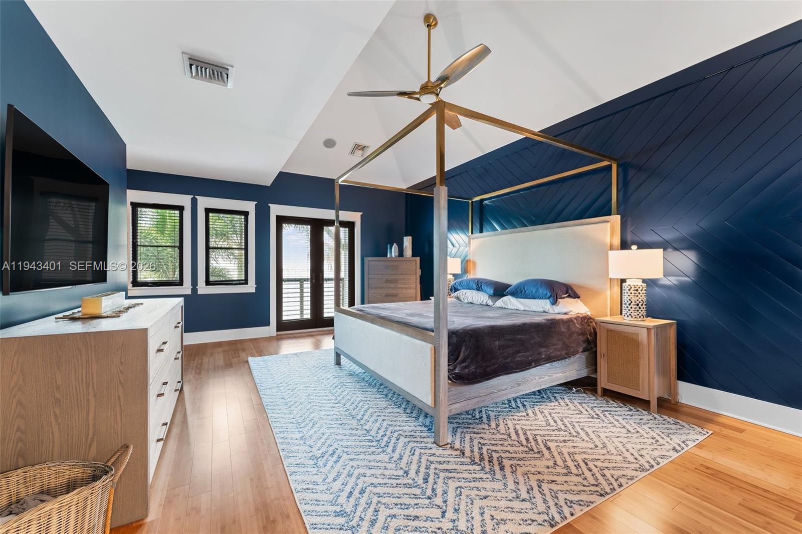 1890 Northwest River Trail Stuart, FL 34994 - Photo 22 of 52 a spacious bedroom with a bed a flat screen tv and balcony view