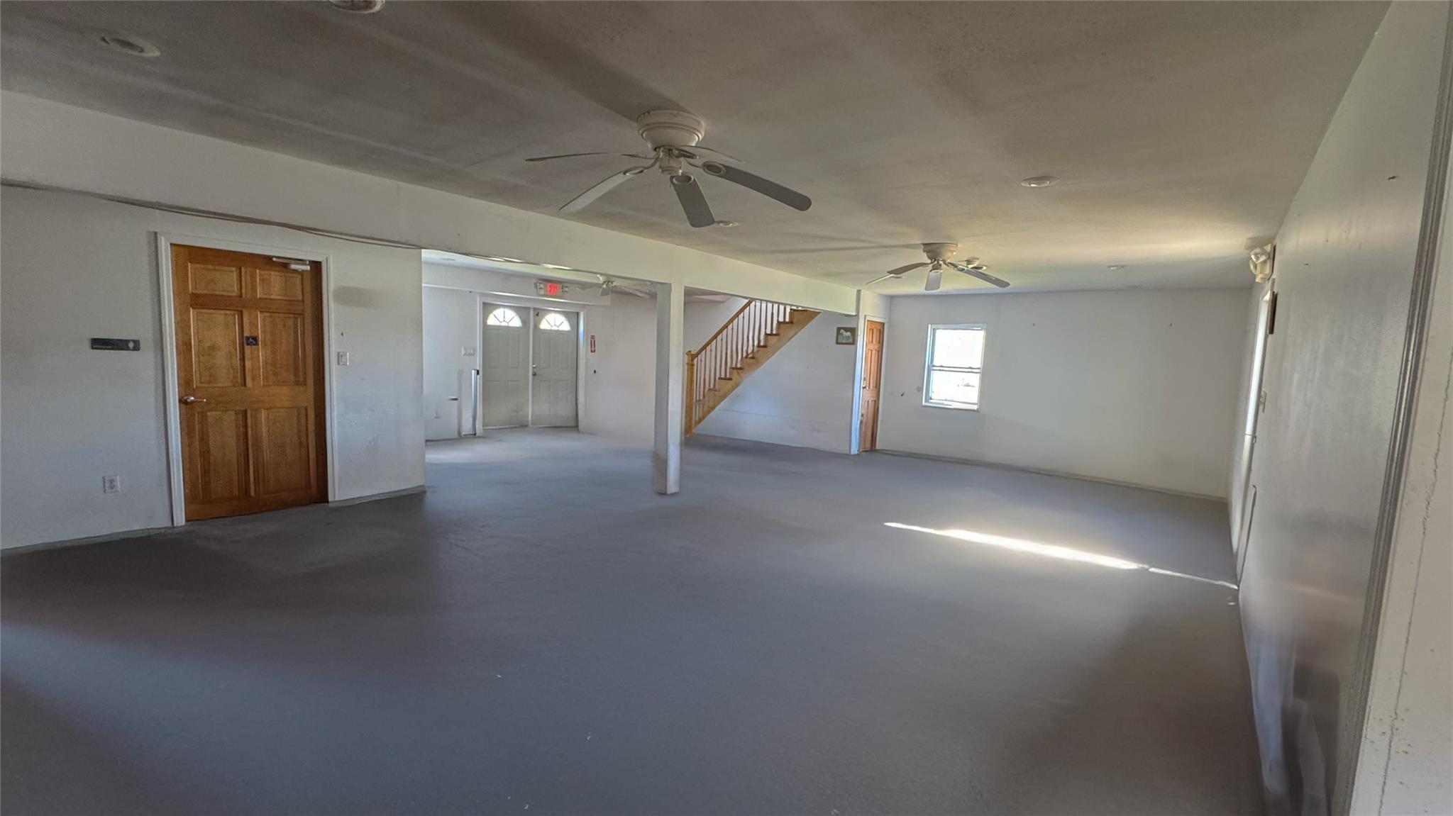 892 Bowbell Road Greene, NY 13778 - Photo 15 of 35 Empty room featuring a ceiling fan, concrete flooring, and stairway