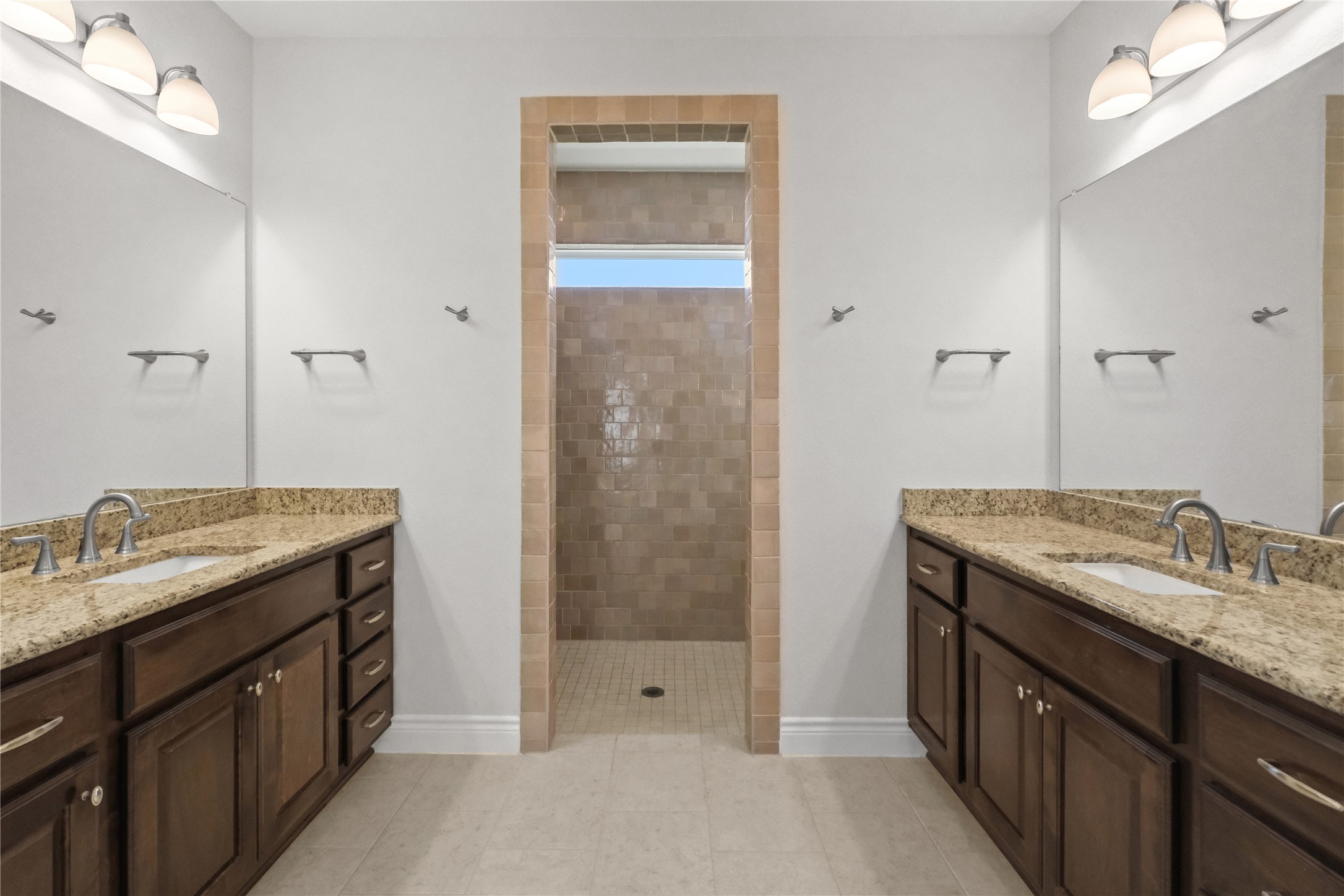 955 Inka Road Salado, TX 76571 - Photo 8 of 39 Double vanities with stone counters frame a tiled walk-in shower in this master bathroom.