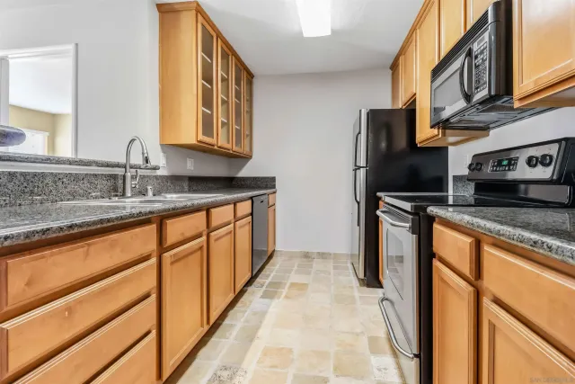 a kitchen with stainless steel appliances granite countertop a sink stove and refrigerator