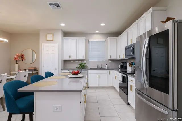 a kitchen with a sink a refrigerator and cabinets