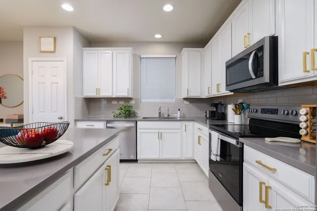 a kitchen with stainless steel appliances granite countertop a sink dishwasher stove top oven and cabinets with wooden floor