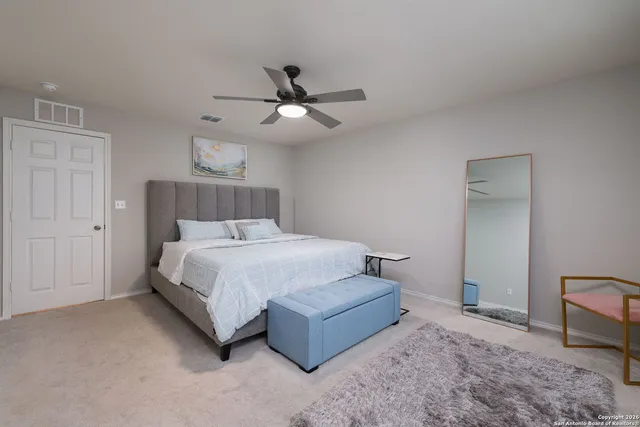a spacious bedroom with a bed and a ceiling fan