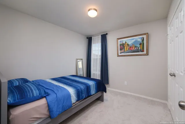 a bedroom with a bed and painting on the wall