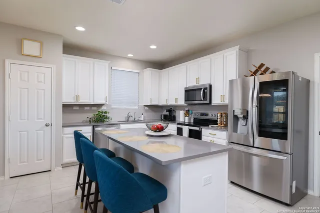 a kitchen with a sink a microwave a refrigerator and cabinets